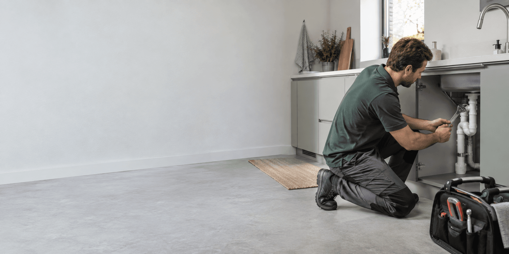 Illustratieve foto van een loodgieter aan het werk in een keuken
